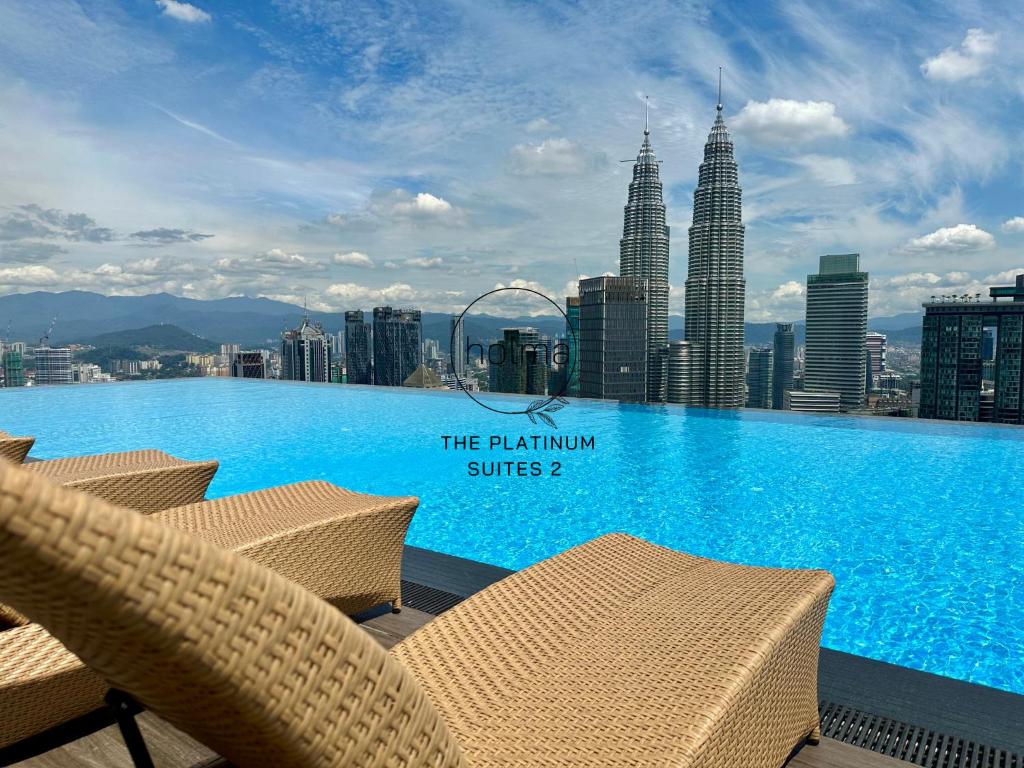 einen Pool mit Stühlen auf dem Dach eines Gebäudes in der Unterkunft The Platinum 2 Kuala Lumpur by HOLMA in Kuala Lumpur