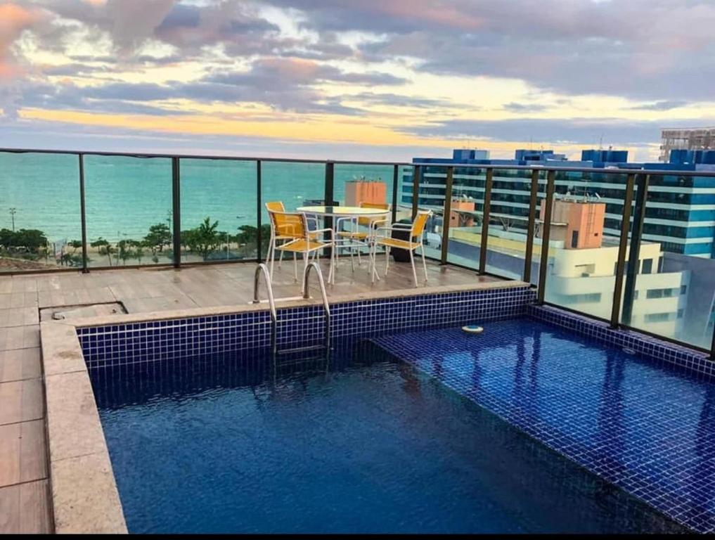 a swimming pool on the roof of a building at Grande Apartamento Beira-Mar 2/4 Pajuçara in Maceió