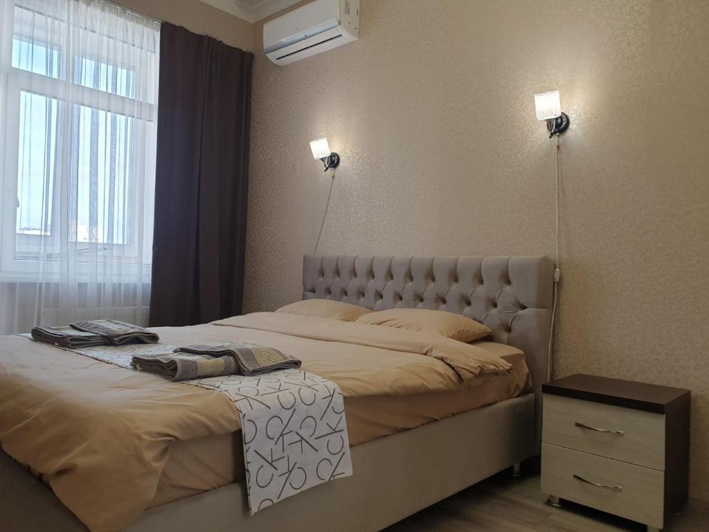 een slaapkamer met een groot bed en een raam bij Elegance 1BD apartment with living room in Chişinău