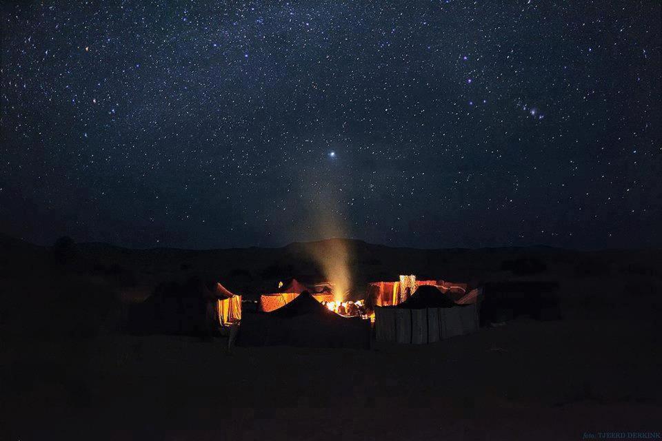 a night scene of a camp with a star filled sky at Desert life in Mhamid
