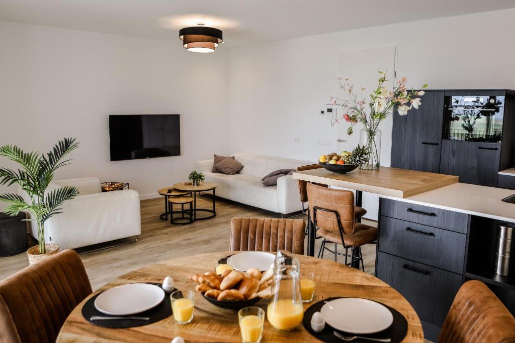 een keuken en een woonkamer met een tafel en stoelen bij Luxe 4 persoons appartement in Residence Marina Kamperland 2c in Kamperland