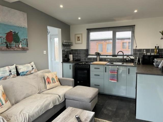 uma sala de estar com um sofá e uma cozinha em S and S Chalets Mablethorpe em Mablethorpe
