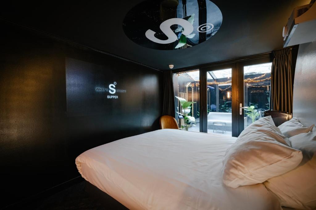 SUPPER Hotel في أمستردام: غرفة نوم بسرير ابيض ونافذة