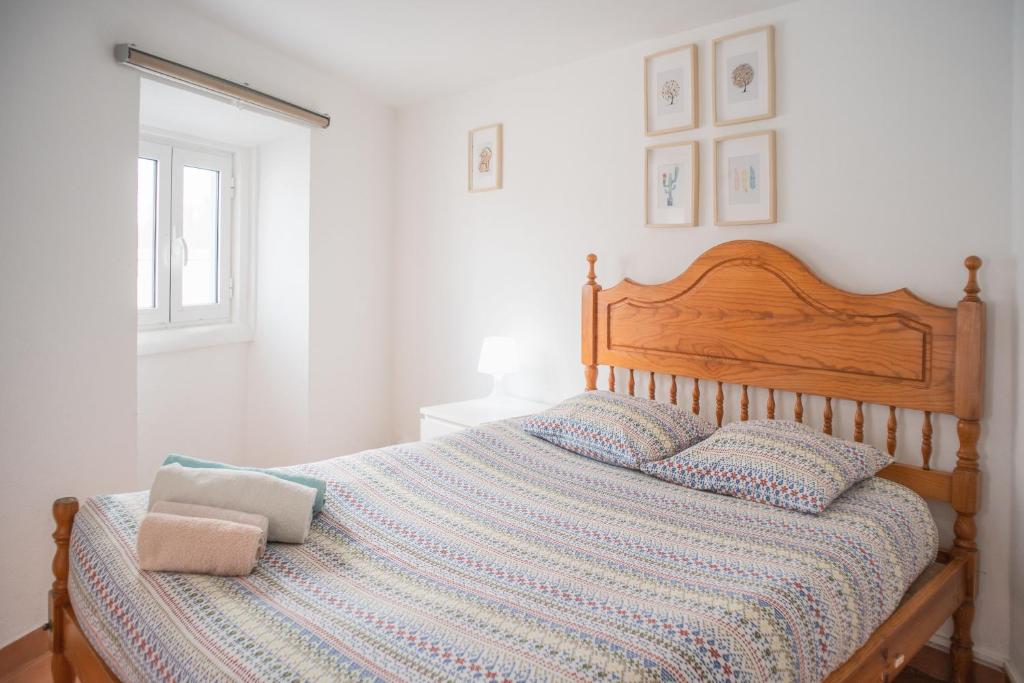 a bedroom with a bed with a wooden head board at Estúdios Lagido - Peniche Surf Camp Working Space & surf in Ferrel