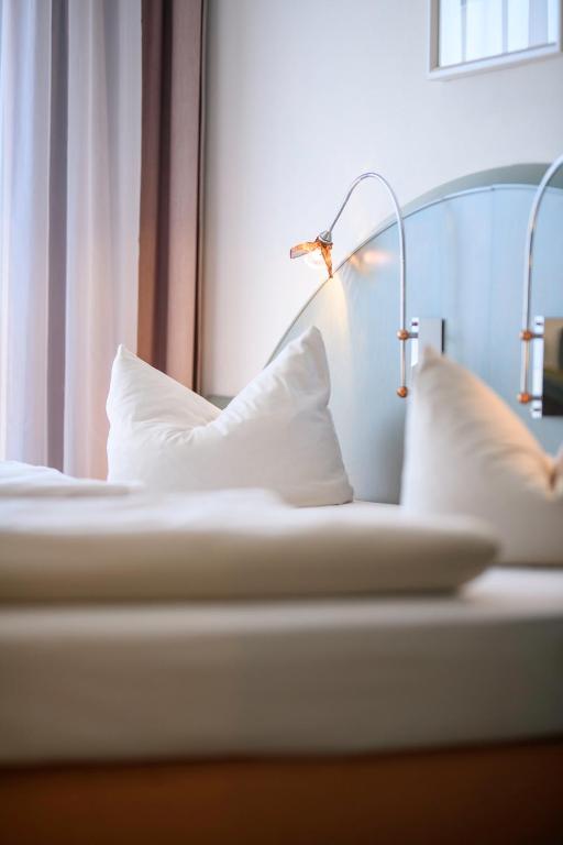 a bed with two pillows and a lamp on it at Ambiente Langenhagen Hannover by Tulip Inn in Hannover