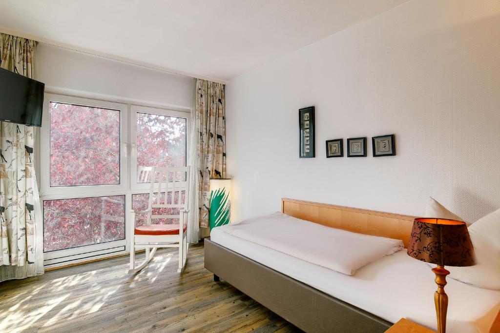 Un dormitorio con una cama y una ventana grande. en Ambiente Langenhagen Hannover by Tulip Inn, en Hannover