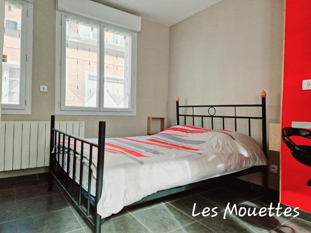 Bett in einem Zimmer mit 2 Fenstern in der Unterkunft Les Mouettes 2 in Le Tréport