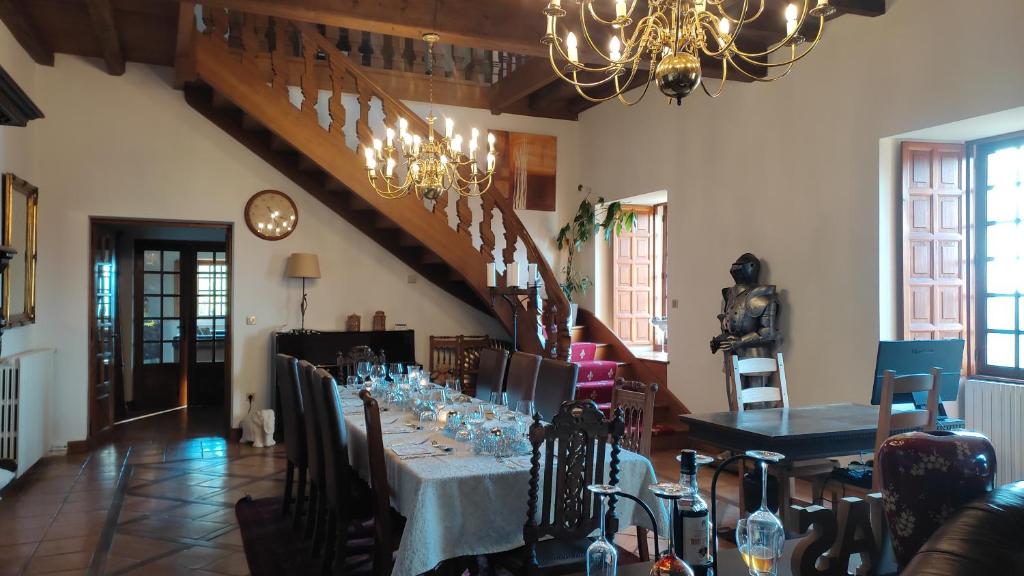 a dining room with a long table and a chandelier at Château de Chauvac - Chambres et table d'hôtes avec vue sur la rivière in Bassignac-le-Bas