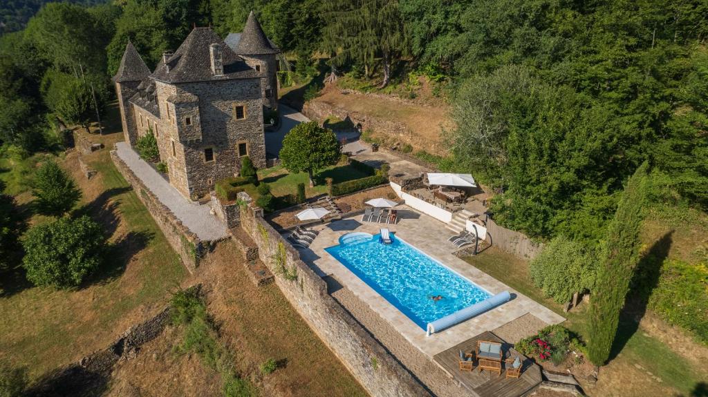 una vista aérea de un antiguo castillo con piscina en Château de Chauvac - Chambres et table d'hôtes avec vue sur la rivière en Bassignac-le-Bas