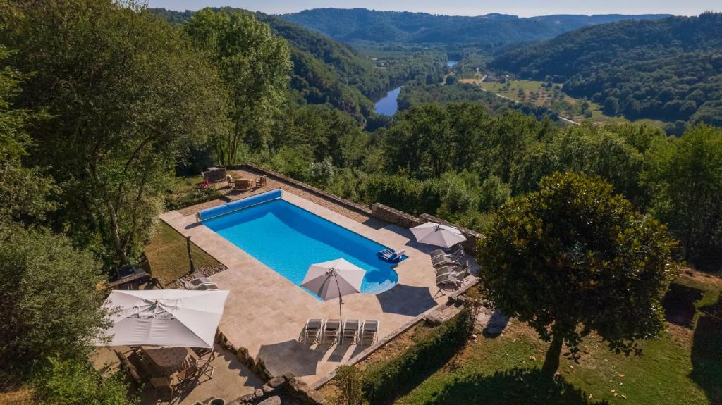 an overhead view of a swimming pool with umbrellas at Château de Chauvac - Chambres et table d'hôtes avec vue sur la rivière in Bassignac-le-Bas