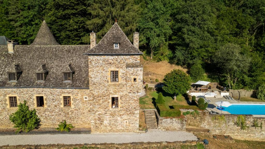 an aerial view of an old stone house with a swimming pool at Château de Chauvac - Chambres et table d'hôtes avec vue sur la rivière in Bassignac-le-Bas