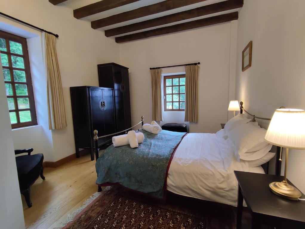 a bedroom with a large bed and a table and a lamp at Château de Chauvac - Chambres et table d'hôtes avec vue sur la rivière in Bassignac-le-Bas