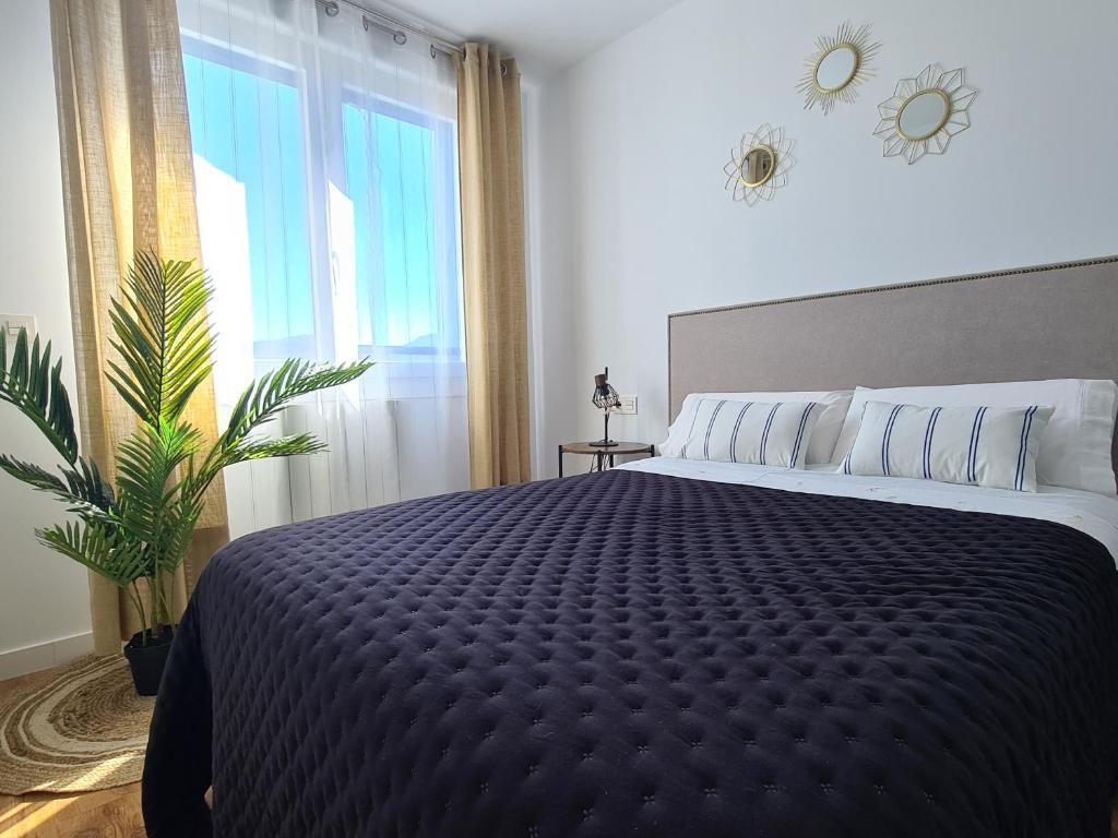 ein Schlafzimmer mit einem großen Bett und einem großen Fenster in der Unterkunft Apartamento Nicores Bidasoa in Irún
