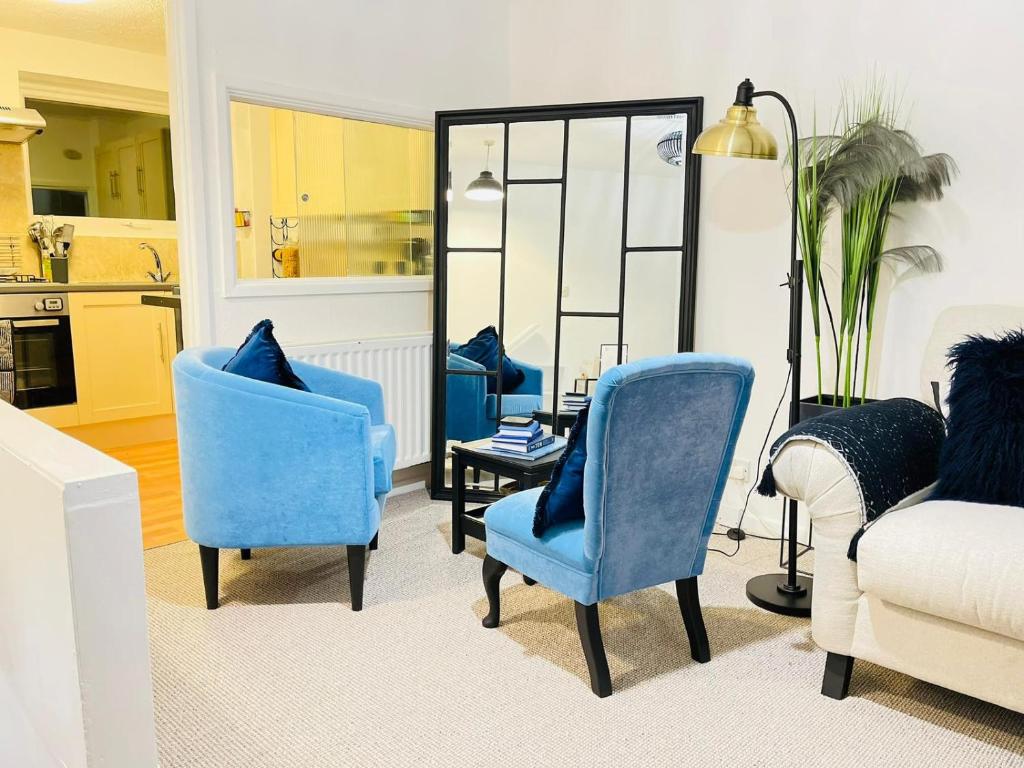 a living room with blue chairs and a mirror at Cambridge Stay Cozy home with Wi-Fi, Parking Perfect for 2 in Cherry Hinton