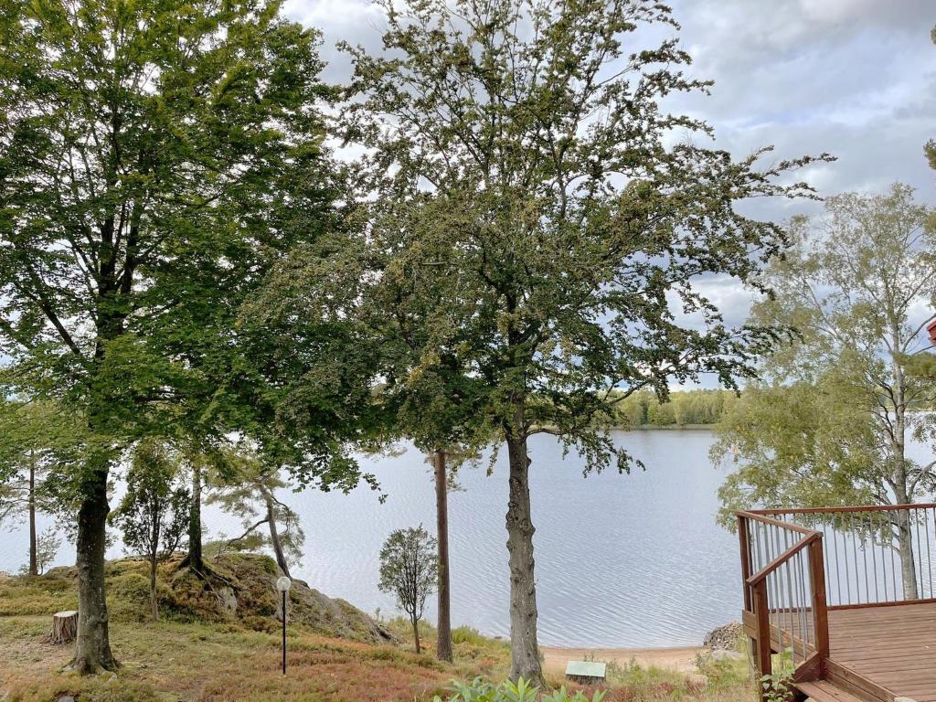 a view of a lake with trees and a wooden deck at Fantastic holiday home with own lake plot by Bolmen, Ljungby in Ljungby