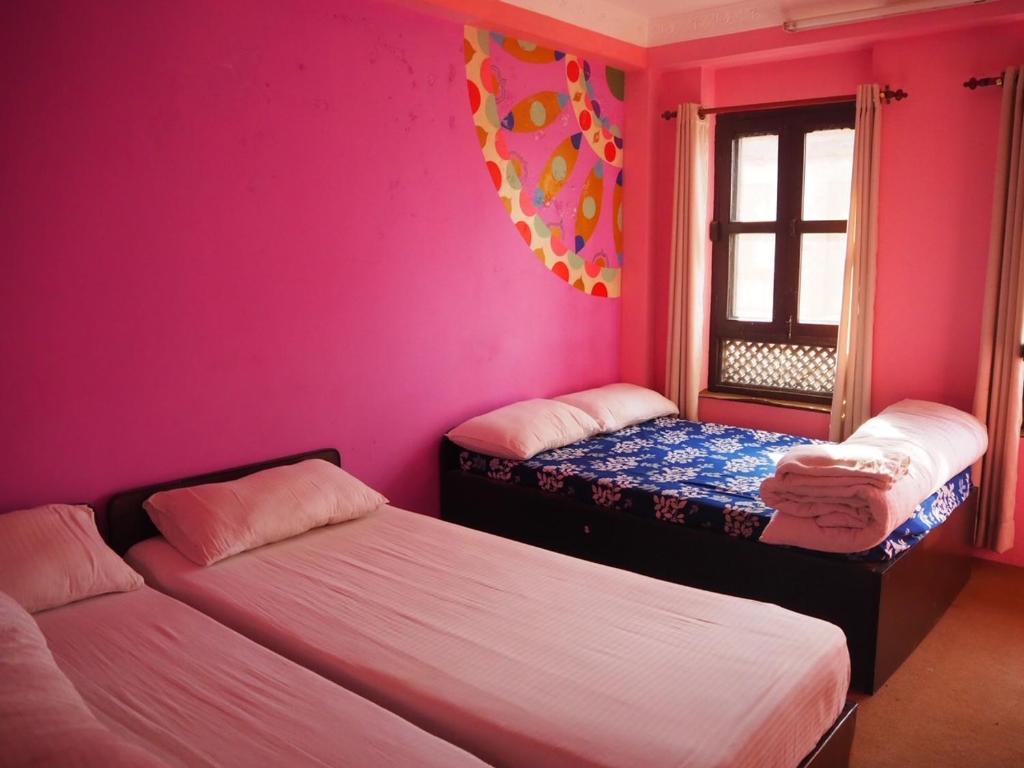 A bed or beds in a room at The Nest Guest House