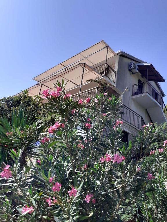 a building with pink flowers in front of it at Apartments Ana in Blato