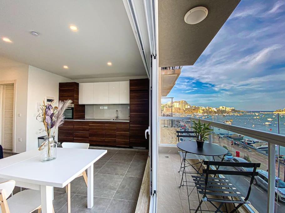 a kitchen and dining room with a view of the ocean at Seafront 1st floor Apartment in Marsaskala by Solea in Marsaskala