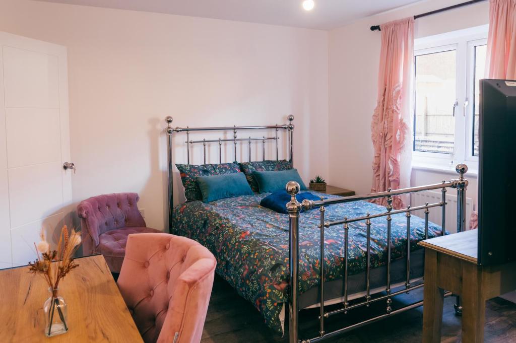 - une chambre avec un lit, une table et une chaise dans l'établissement Oakley Place - Room A Deluxe Ensuite, à Bristol