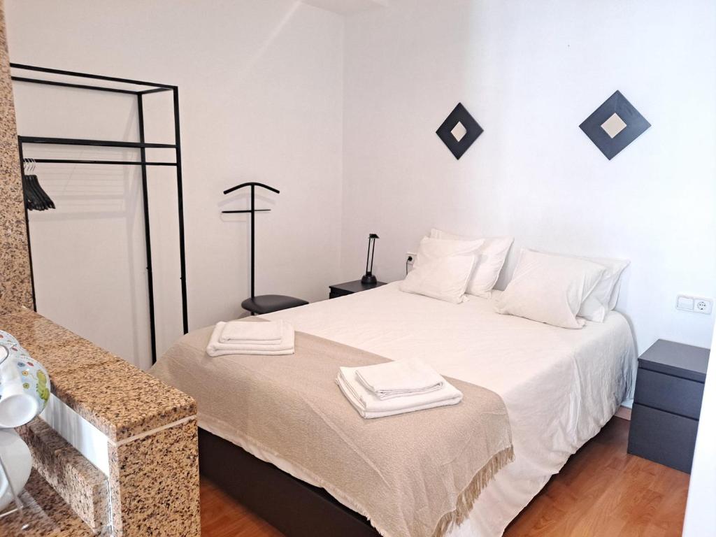 1 dormitorio con 1 cama blanca y 2 toallas en Fantástico loft cerca centro by Lofties, en Terrassa