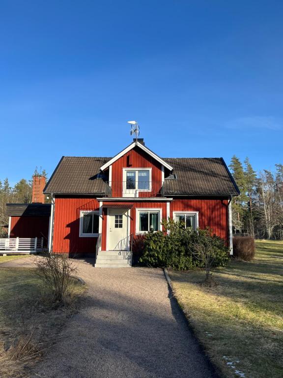 uma casa vermelha com um telhado preto em Ljungmanshorva em Vimmerby