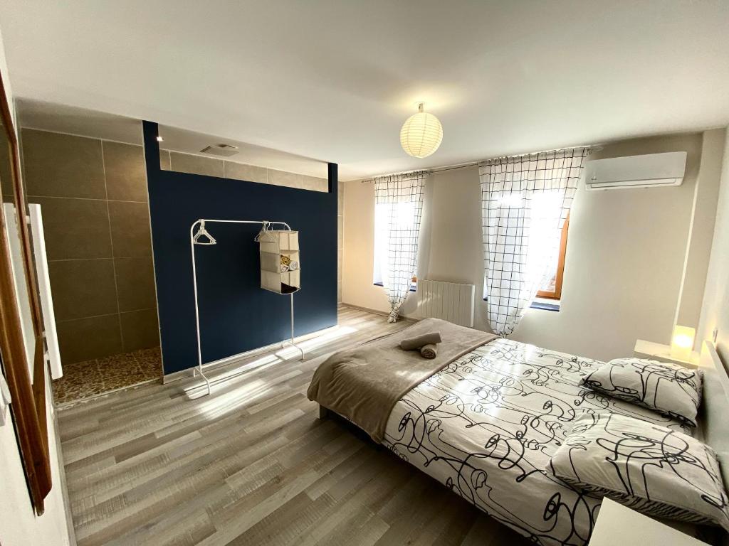 1 dormitorio con 1 cama grande y pared azul en Spacieux, Climatisé, Quartier Calme, Proche Château, Le Cocon De Joy en Carcassonne