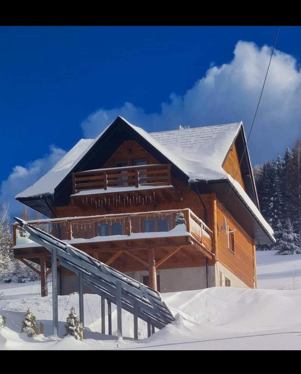 a log cabin in the snow with snow at Gorczańska Chata z tarasem widokowym in Poręba Wielka