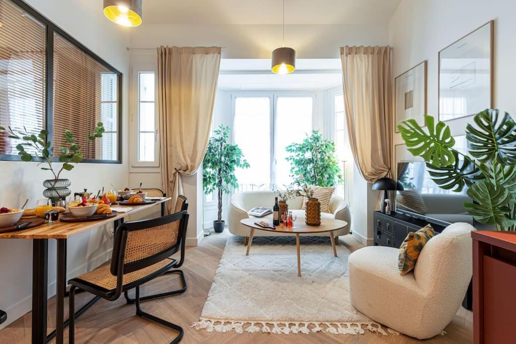un salon avec une table et un salon avec des plantes dans l'établissement MY CASA - HEROLD 60 - Cosy Apartment Suite with AC Downtown, à Nice