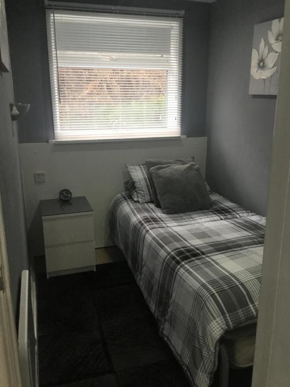 a small bedroom with a bed and a window at Ground Floor Hillview 2 bedroom Apartment in Brean