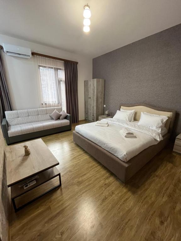 Meghri的住宿－NAREMA FAMILY HOTEL Meghri，一间卧室配有一张大床和一张沙发