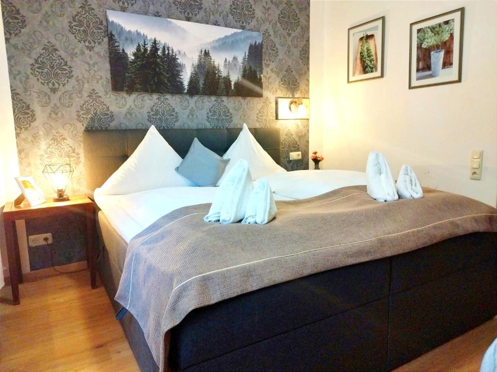 a bedroom with a large bed with blue pillows at Stadthotel Deggendorf in Deggendorf