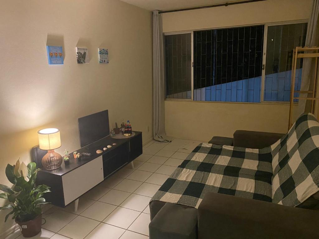 sala de estar con cama y sofá en Apartamento ao lado da UFSC, en Florianópolis