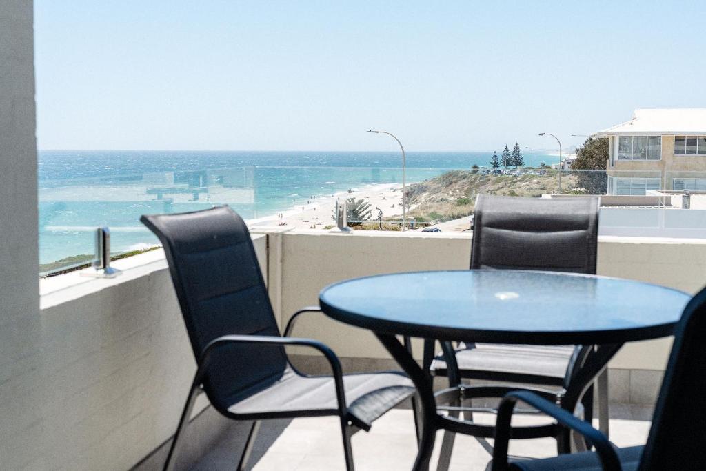 stół i krzesła na balkonie z widokiem na plażę w obiekcie Cottesloe Beach View Apartments #11 w mieście Perth