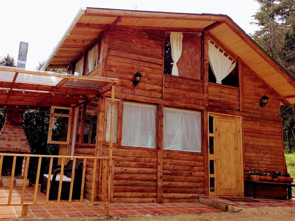 Cabaña de madera con puerta y ventanas en La Arboleda, en Tilatá