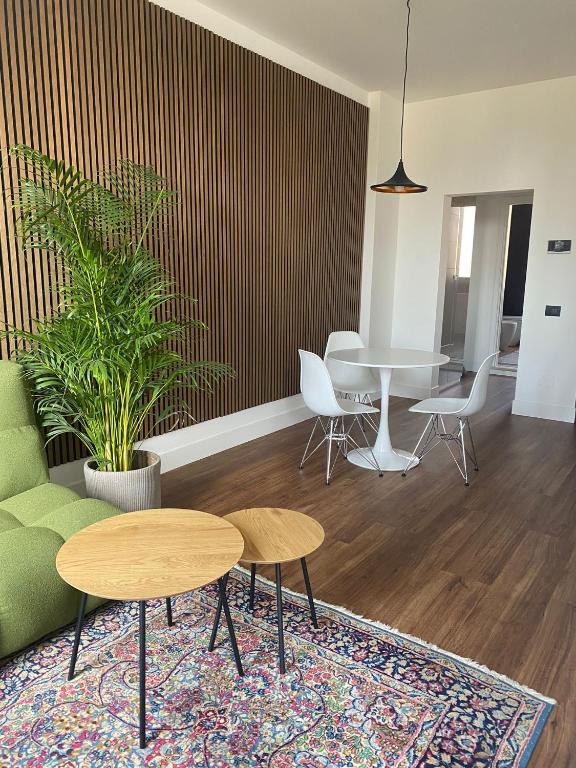a living room with two tables and a table and chairs at LOFT MANZONI 37 in Cremona