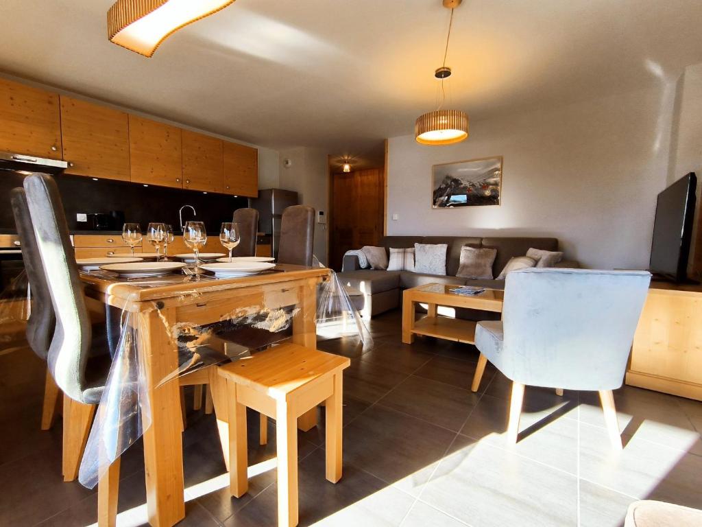 une cuisine et un salon avec une table et des chaises dans l'établissement Appartement lumineux 2 chambres, terrasse sud, parking, WiFi - FR-1-624-128, à Samoëns