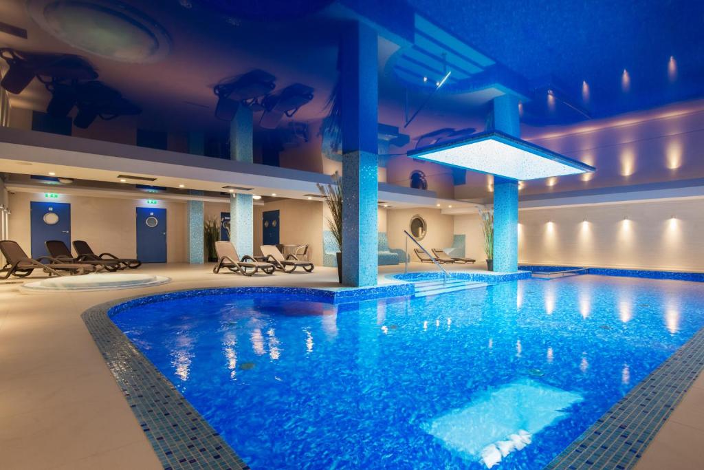 una gran piscina en un hotel con iluminación azul en Hotel Szafir en Jastrzębia Góra