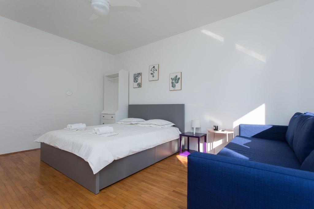 a bedroom with a bed and a blue couch at BEUS DOWNTOWN in Split