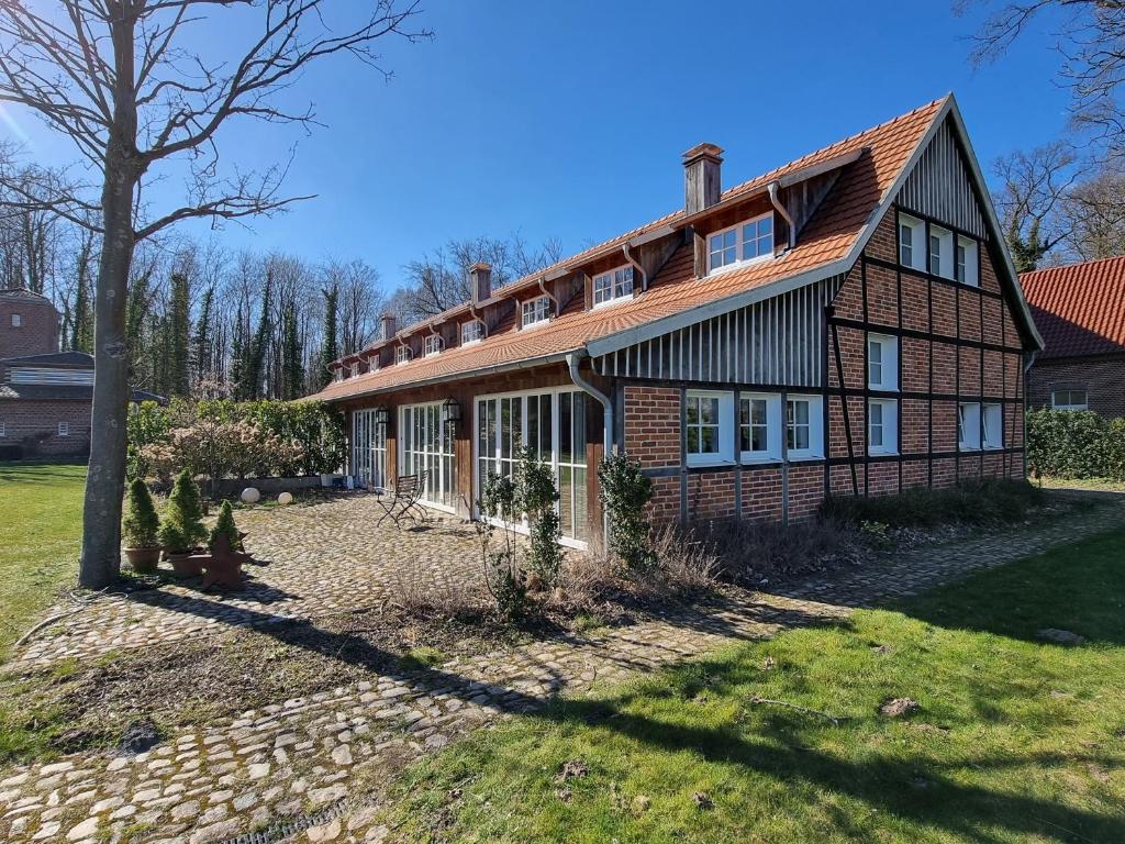 una gran casa de ladrillo con un árbol en el patio en Thuers im Busch - Gute Stube +, en Münster