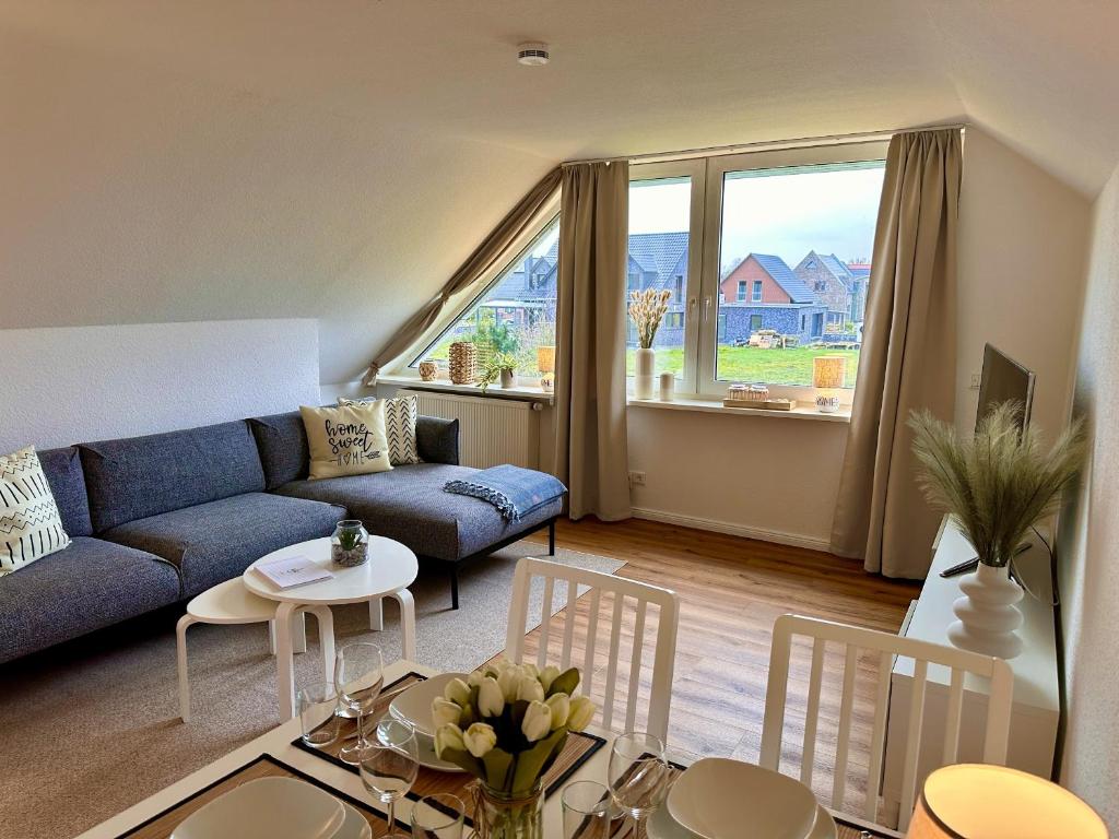 ein Wohnzimmer mit einem Sofa und einem Tisch in der Unterkunft Ferienwohnung Deichblick in Emden
