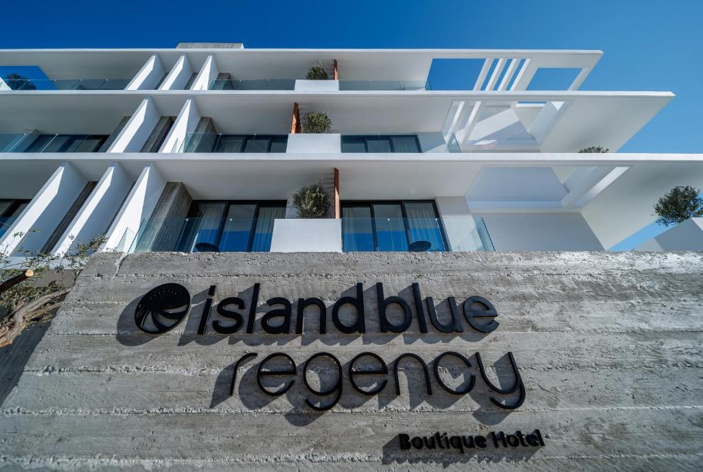 un edificio blanco con un letrero en una escalera en Regency Boutique Hotel Holiday Suites en Pafos