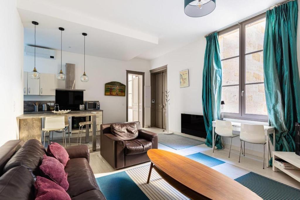 uma sala de estar com um sofá e uma mesa em Magnifique Appartement avec climatisation en Hyper Centre de Bordeaux em Bordéus