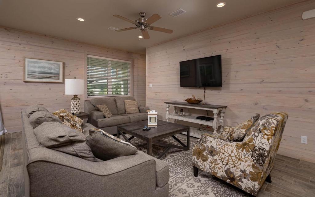 een woonkamer met 2 banken en een flatscreen-tv bij Jetty Life 473 home in Gulf Shores