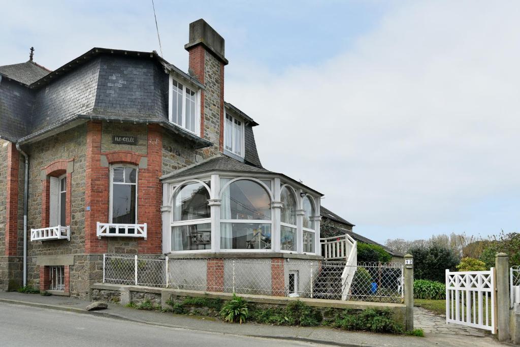 Cette ancienne maison en briques possède une grande fenêtre. dans l'établissement Ile Celée - Maison de caractère proche plage, à Dinard