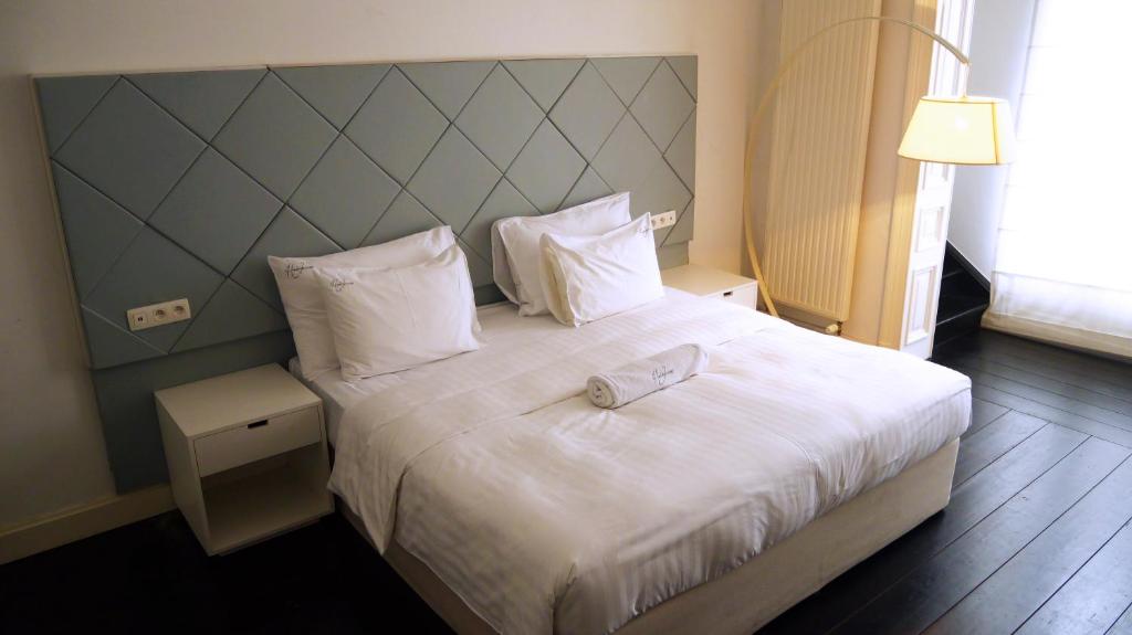 a hotel room with a bed with a towel on it at Heirloom Hotels - A Flemish Tale in Ghent