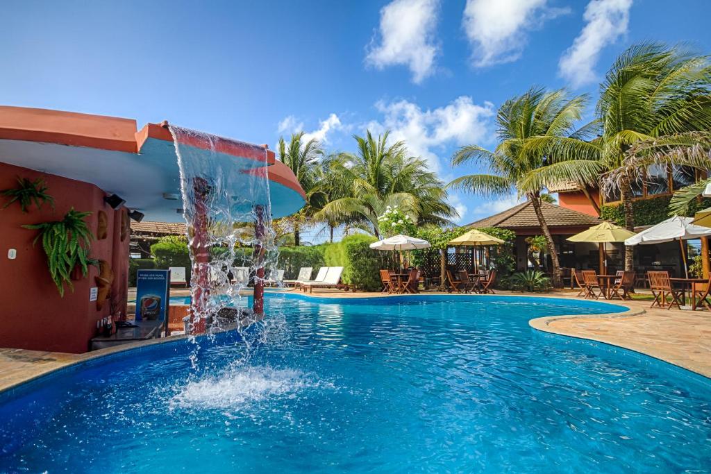 uma piscina num resort com uma fonte de água em Aruanã Eco Praia Hotel em Aracaju