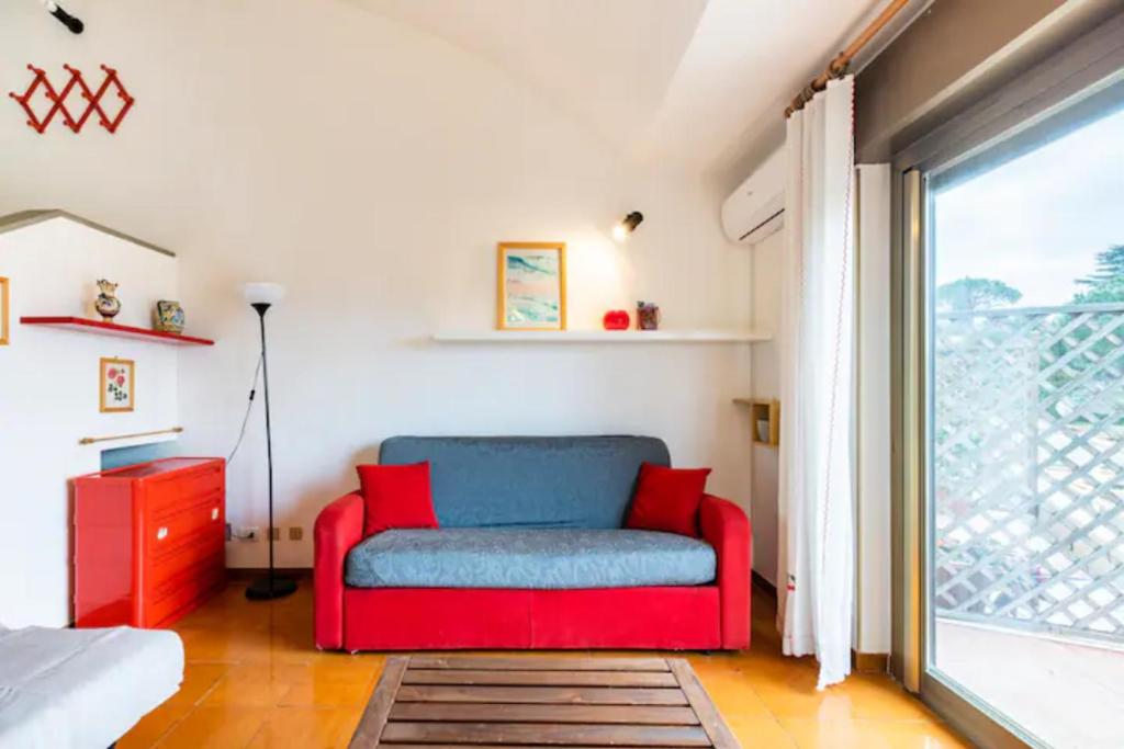 einen roten und blauen Stuhl in einem Zimmer mit Fenster in der Unterkunft CASA MANU FINALE LIGURE in Finale Ligure