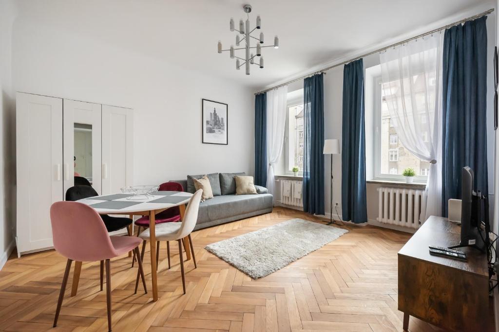 a living room with a table and chairs and a couch at Chmielna Warsaw City Centre Apartment in Warsaw