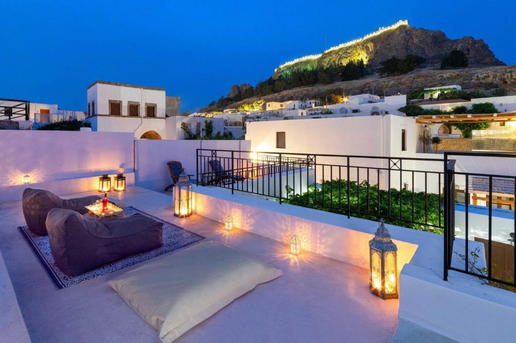 un patio con sofá y luces por la noche en Lindos Villa Petra with Acropolis View, en Lindos