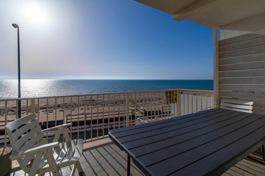 una terrazza con tavolo e sedie sulla spiaggia di Appartamento vista mare Scoglitti a Scoglitti